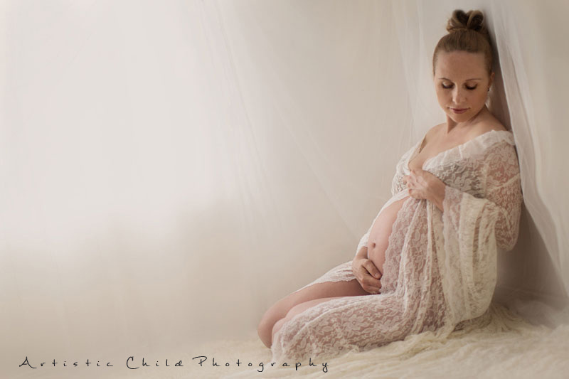 Professional London Maternity Photo Session 12 pregnant woman sitting on the floor and looking at her bump | London