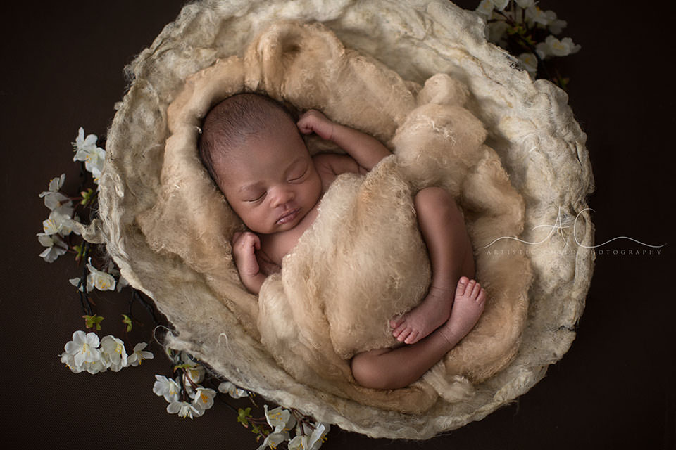 Best London Newborn Photography | Nia 7 photo of a newborn baby girl sleeping peacefully while posed in a newborn baby nest prop | London