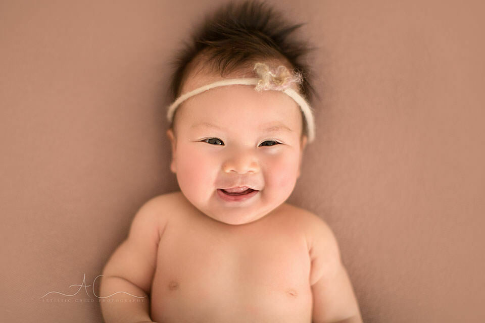 Professional Bromley Baby Images | Eleanor 4 100 days old baby girl smiling for the camera | London