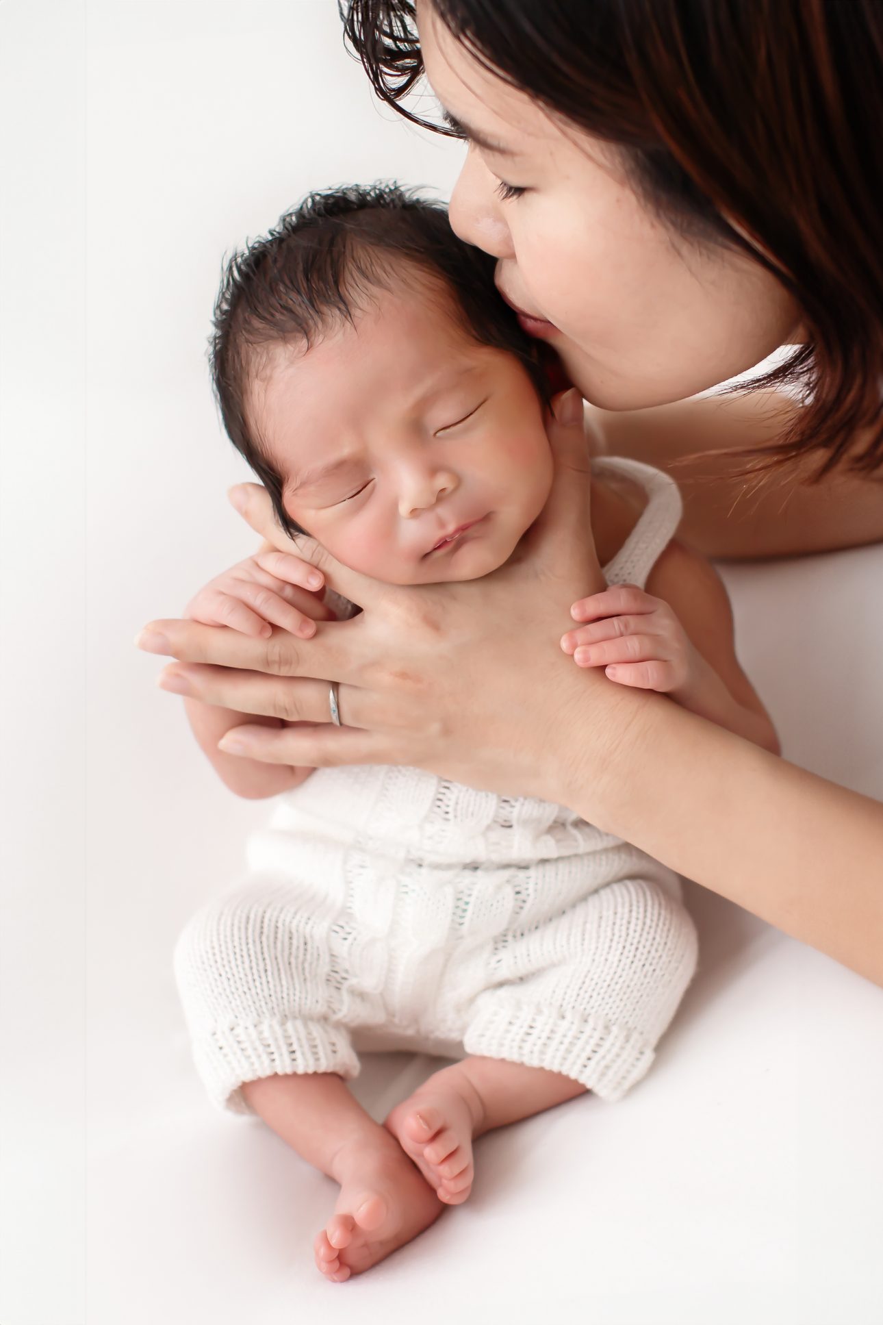 Bromley Newborn Photographer | Mum kissing her newborn son during a newborn photoshoot in Bromley