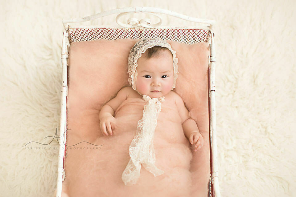 Professional London Baby Girl Portraits | Eleanor 5 3 months old baby girl lying in a small metal bed prop | London