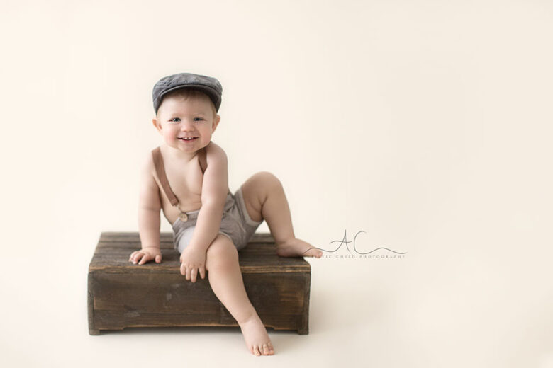 Professional London Toddler Photography Offer | 1 year old toddler boy sitting on top of the wooden crate