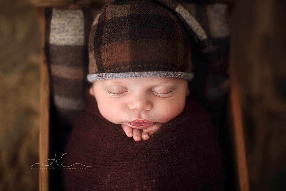 South East London Newborn Baby Boy Images | Finn 1 South East London Newborn Baby Boy Images | a close up portrait of a newborn baby boy wearing a checked brown sleepy hat