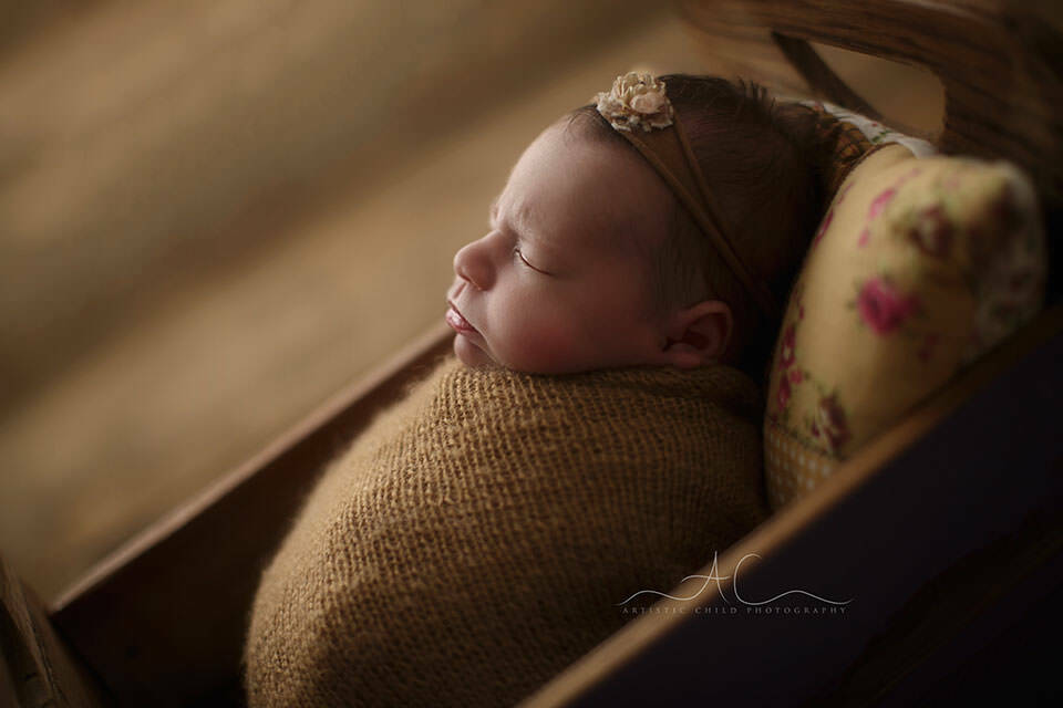 Bromley Newborn Baby Photography Services | Alicja 4 Bromley Newborn Baby Photography Services | a backlit profile portrait of a newborn baby girl sleeping swaddled in the small wooden bed prop