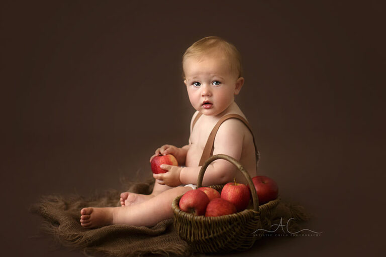 South East London Baby Boy Photos | Reginald 5 South East London Baby Boy Photos | portrait of a 10 months old baby boy playing with a basket full of red apples