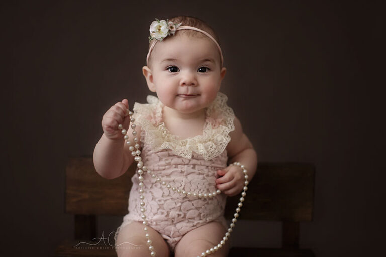 Bromley Baby Photography Offer | Beatrice 4 Bromley Baby Photography Offer | 8 months old baby girl plays with a pearl neckles