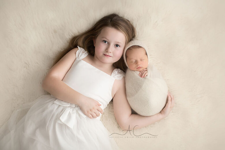 South East London Sibling Pictures | beautiful portrait of a 6 year old girl holding her newborn baby brother