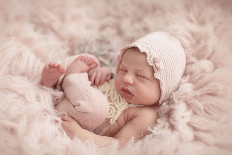 Professional Bromley Newborn Baby Photo Session | newborn baby girl photographed wearing a cute pink romper