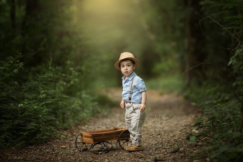 South East London Outdoor Toddler Images | portrait of a toddler boy playing with a wooden trolley in the park