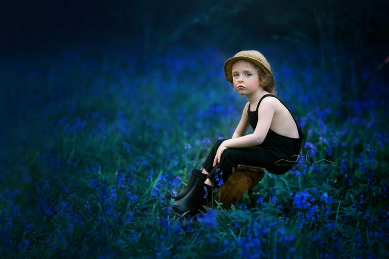 Best Bluebells London Children Photos | portrait of a 4 year old boy sitting on a leather steps in the middle of bluebells