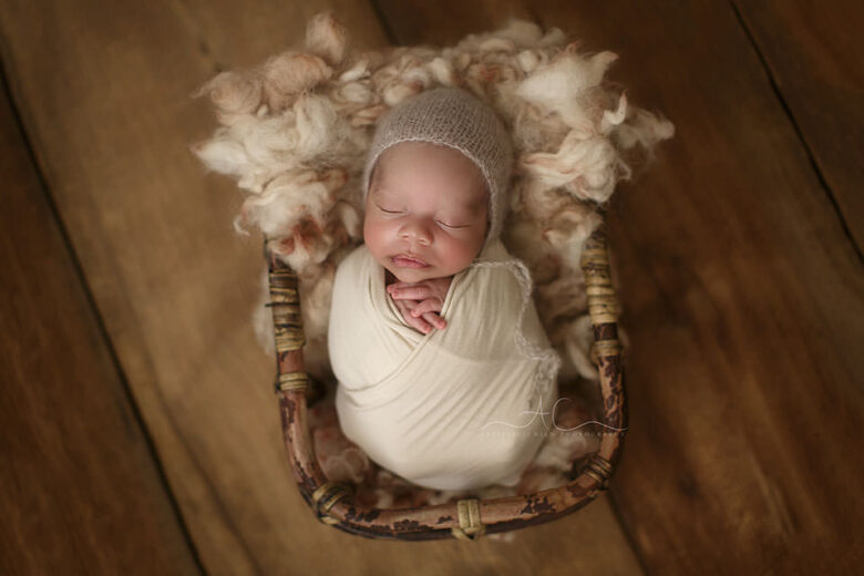 Top London Newborn Photo Session | photo of a newborn baby boy sleeping in a bamboo basket