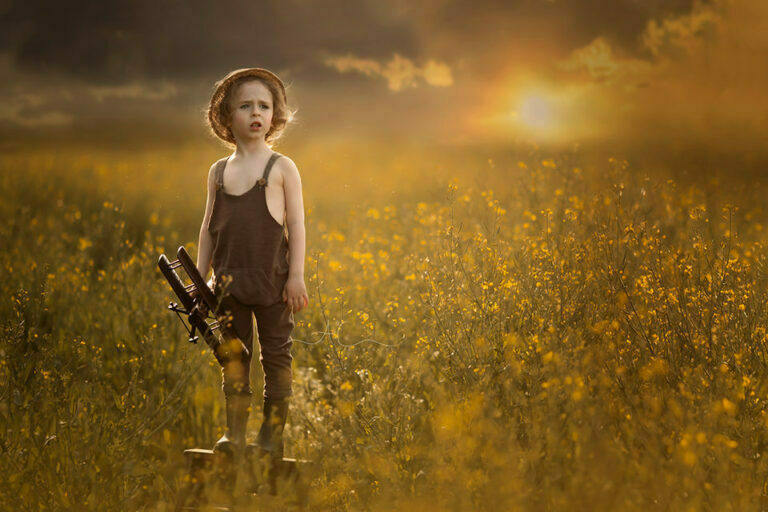 Beautiful London Children Photography in Rapeseed Field 10 Beautiful London Children Photography in Rapeseed Field | 4 year old boy stands on the wooden step ladder and holds an aeroplane while gazing ahead during the sunset in a rapeseed field