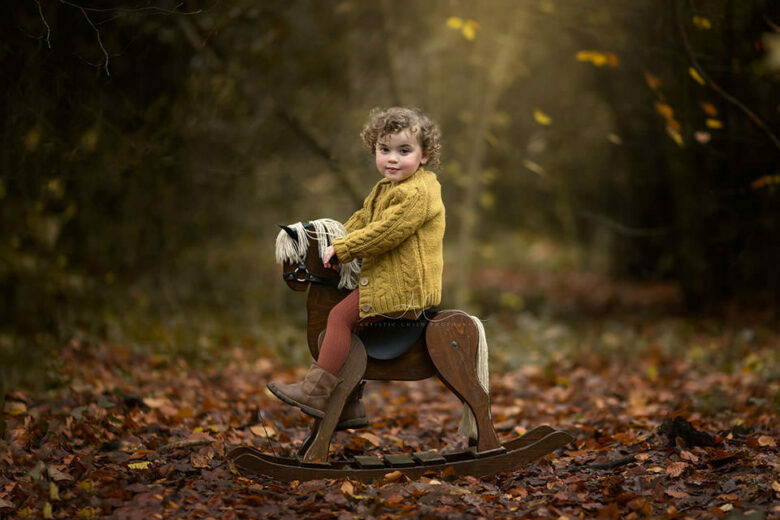 Autumn London Toddler Photo Session | beautiful portrait of a 2 years old girl on a rocking horse taken in London park during autumn season
