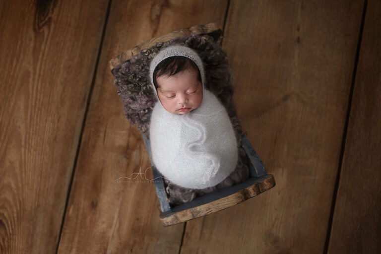 Best London Newborn Photo Session | Jayden 5 Best London Newborn Photo Session | portrait of a newborn baby boy sleeping in a blue wooden cradle
