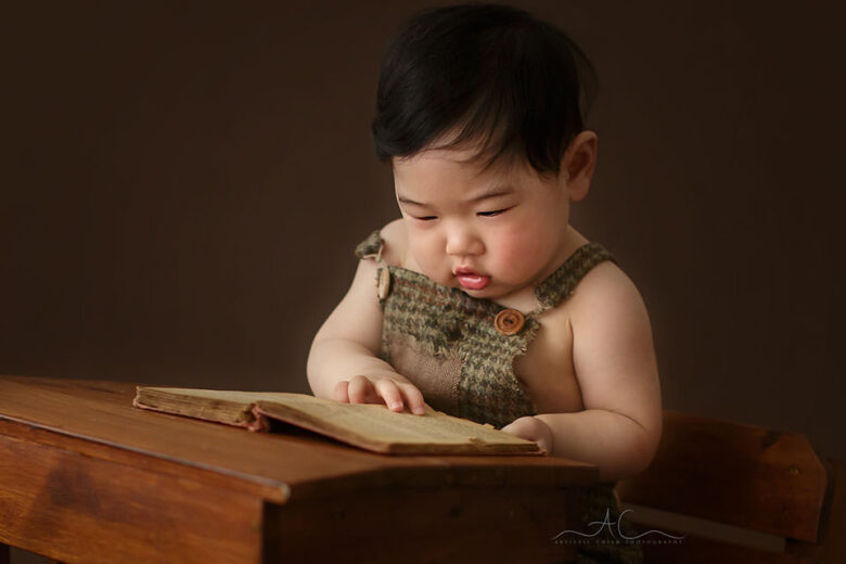 South East London Baby Boy Photographer | a close up portait of a baby boy reading a book