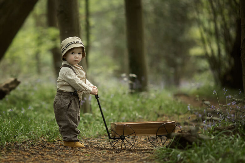 Spring London Toddler Photo Session | 1 year old boy playing with wooden trolley in woods
