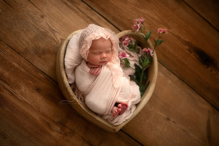 photo of a newborn baby girl pictured in a wooden heart bowl with flowers | Bromley