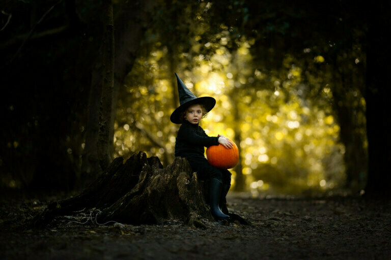 Top London Children Halloween Photos | portrait of a 6 years old boy wearing a witch's hat and holdring a pumpkin in woods