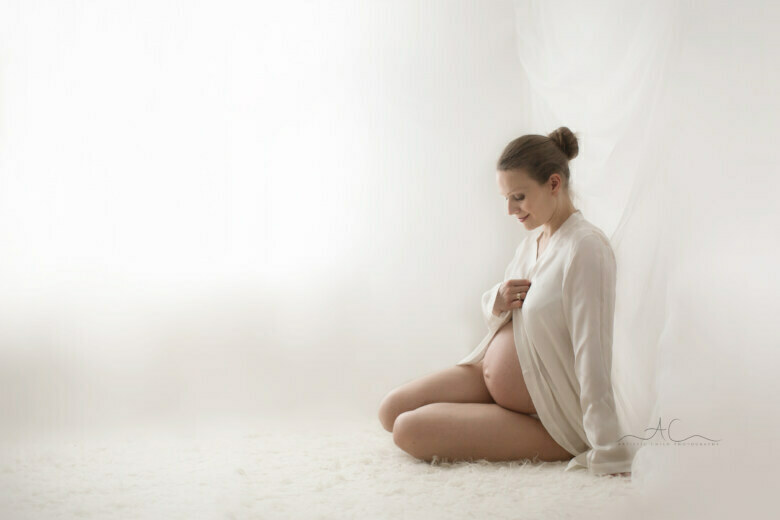 Best South East London Maternity Photographer | natural portrait of future mum looking down at her bump