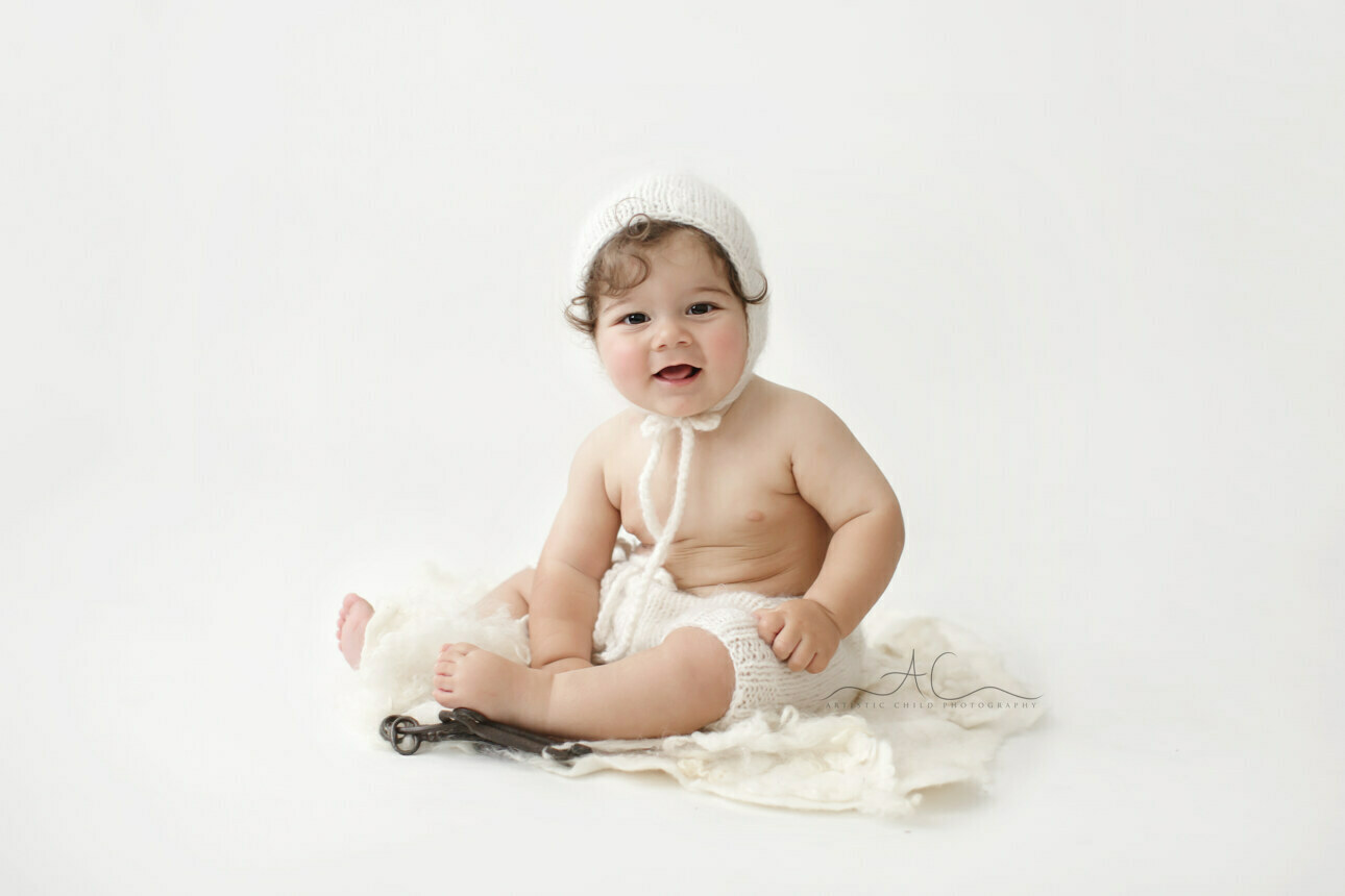 Best London Baby Pictures | portrait of a baby boy wearing a white knitted bonnet