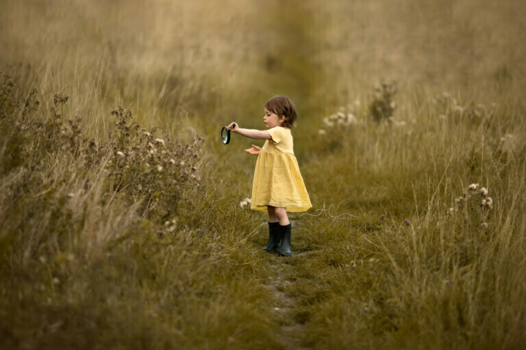 Awesome South East London Children Photos | 3 years old girl plays with magnifying glass during an outdoor photoshoot