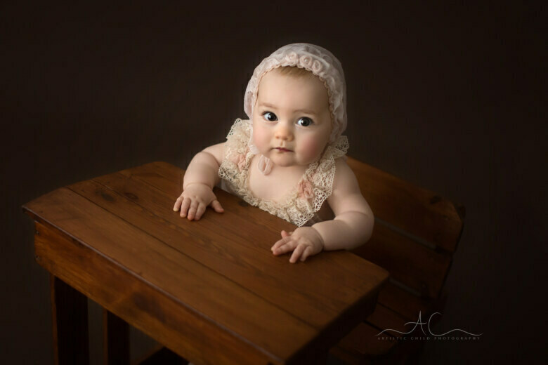Unique Bromley Baby Photography | portrait of a beautiful 7 months old baby girl sitting a an old school desk