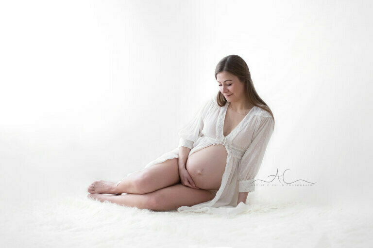 Natural Bromley Pregnancy Photography | classic portrait of a pregnant woman looking down at her pregnant bump
