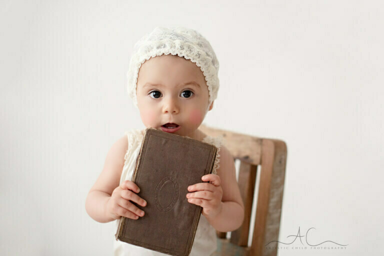 Beautiful London Toddler Pictures | portrait of a 16 month old toddler girl holding an old brown book