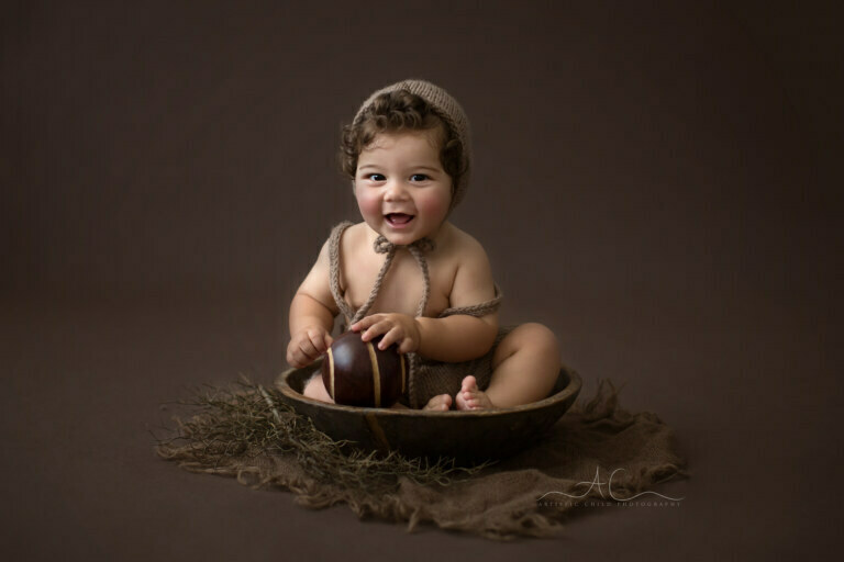 Top Bromley Baby Boy Photos | 7 months old baby boy sitting in a wooden bowl during the professional photoshoot
