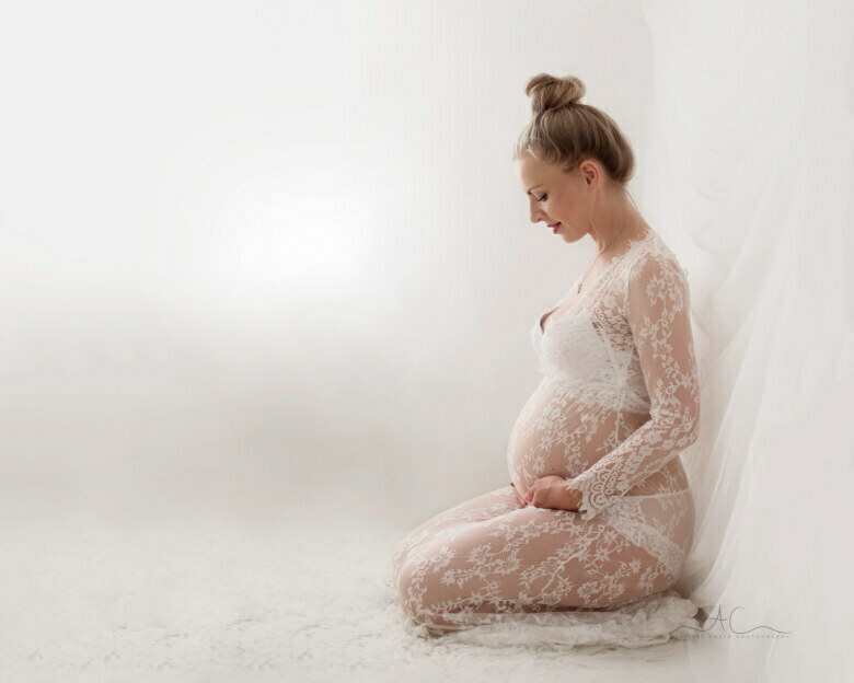 Professional Bromley Pregnancy Images | backlit portrait of a pregnant woomen holding her bump