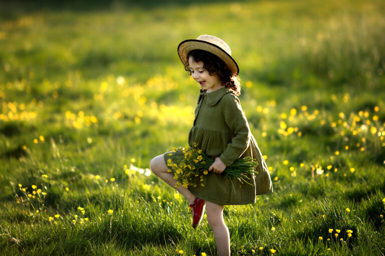 London Spring Mini Sessions | 2026 4 London Spring Family Mini Sessions | a girl in a straw hat walking through a wildflower field