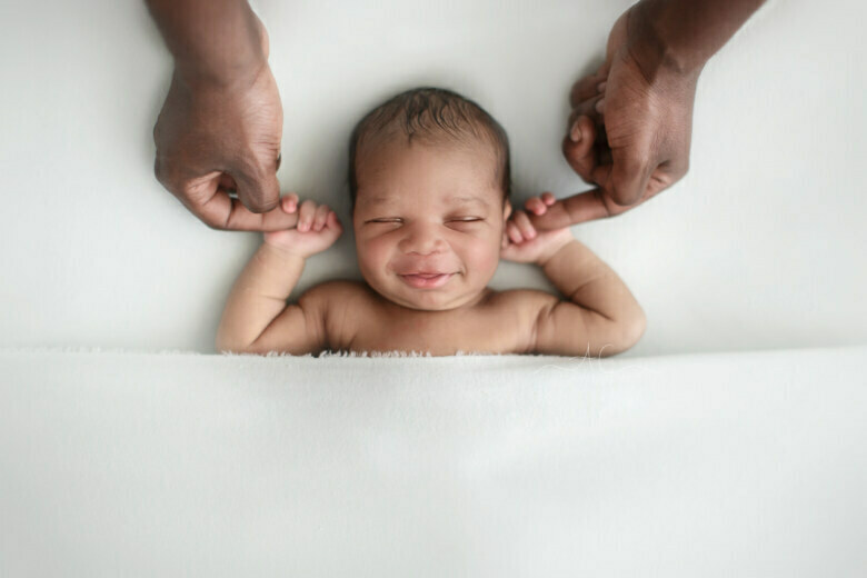 Best South East London Newborn Images | newborn baby boy holds his Dad fingers and smiles