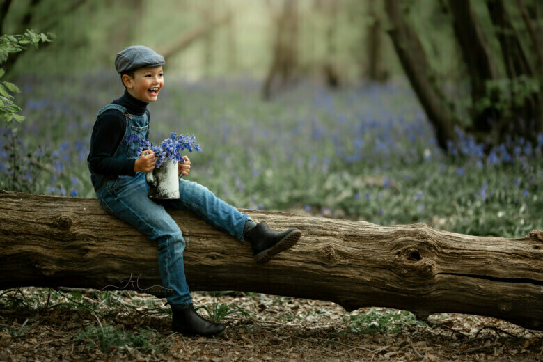 Magic London Children Bluebell Mini Photoshoot | 7 year old boy seats on a tree log and admires bluebells in the woods