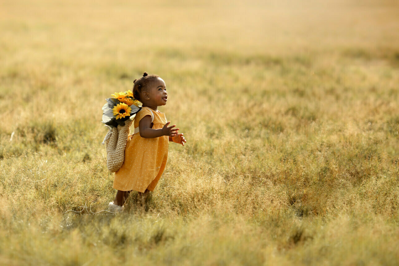 Beautiful London Toddler Photography | Dassah 1 Beautiful London Toddler Photography | happy 1 year old girl runs through the meadow with sunflowers on her back