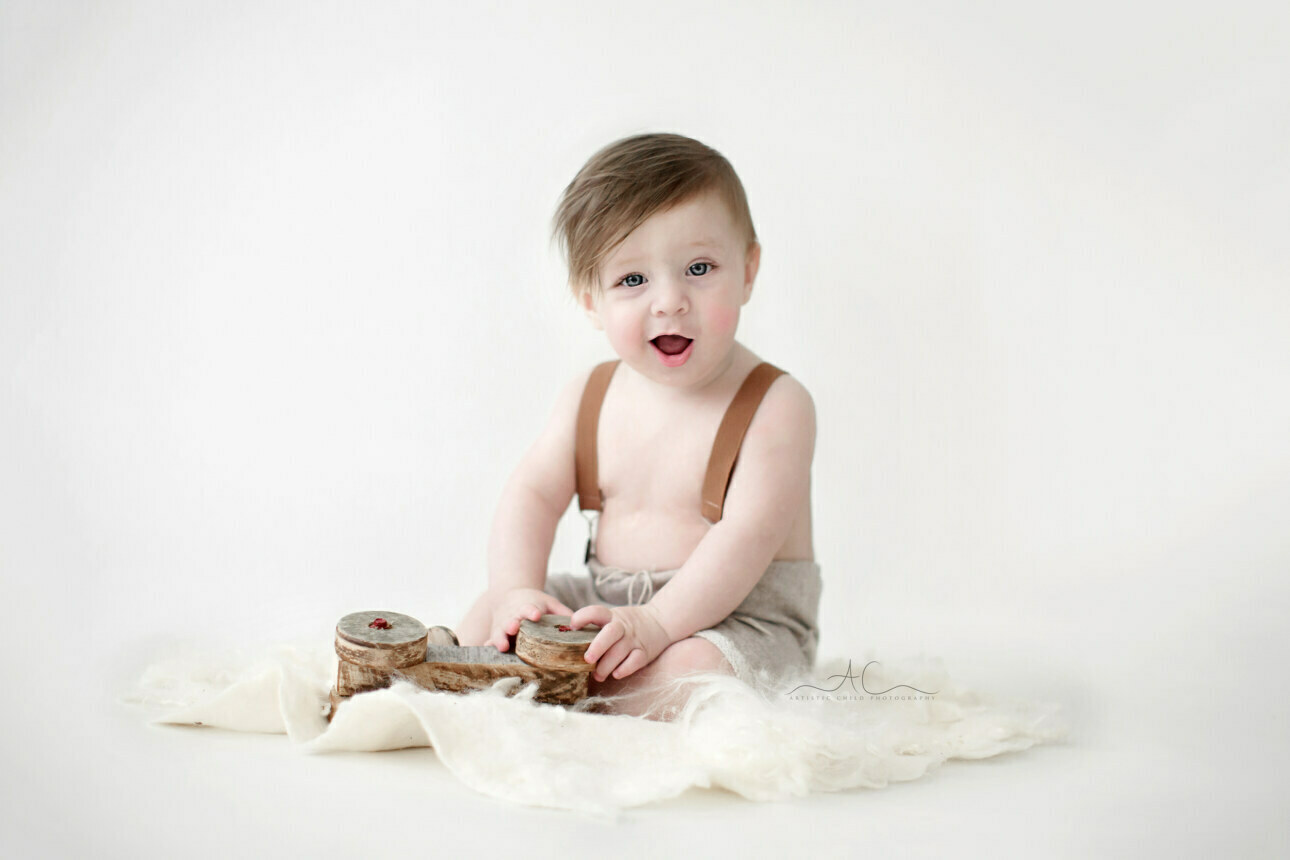 Gorgeous Bromley Baby Boy Photos | 7 months baby boy plays with a wooden car during a professional photoshoot