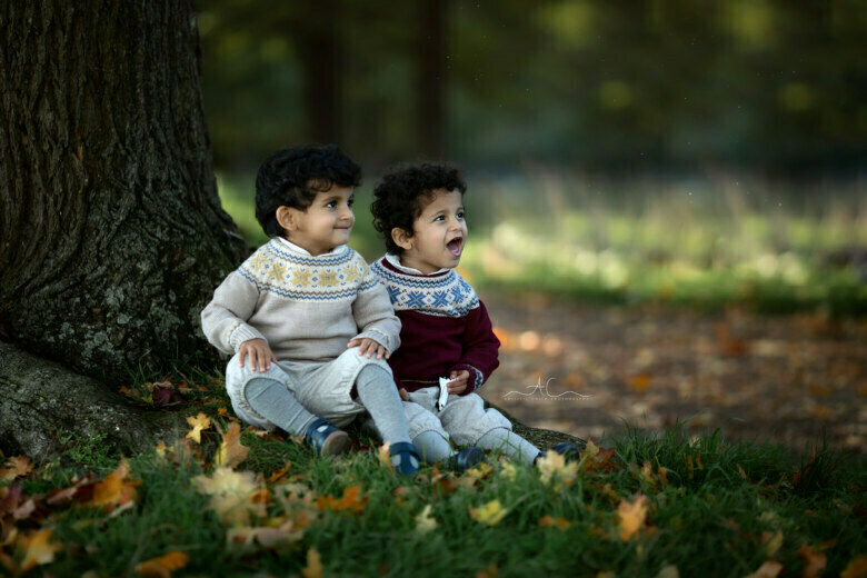 Amazing London Twins Photos | 2 brothers sitting under a large tree and watching the plane passing by