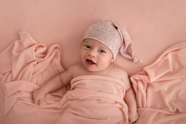 Awesome South East London Newborn Photos | smily photo of a newborn baby girl wearing a sleepy hat