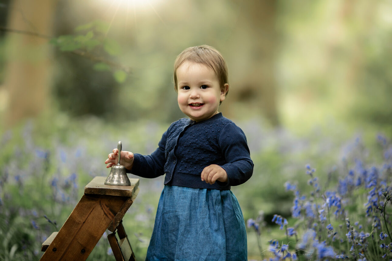 6 Magical London Toddler Bluebell Photos | Julia 3 photo of a 1 year old girl playing with a bell in the woodlands full of bluebells