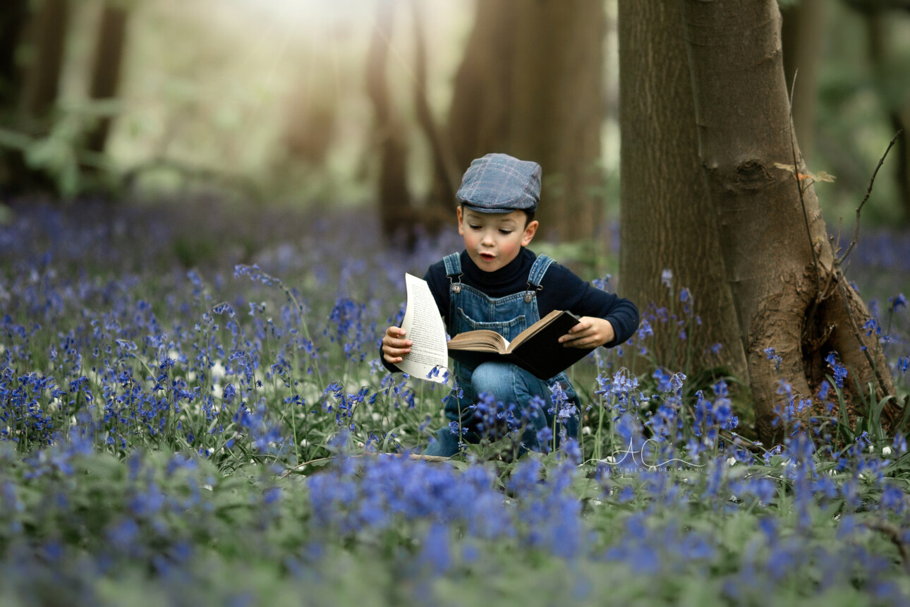 Beautiful London Kids Bluebells Photos | 7 year old boy enjoying a book in the wood full of bluebells