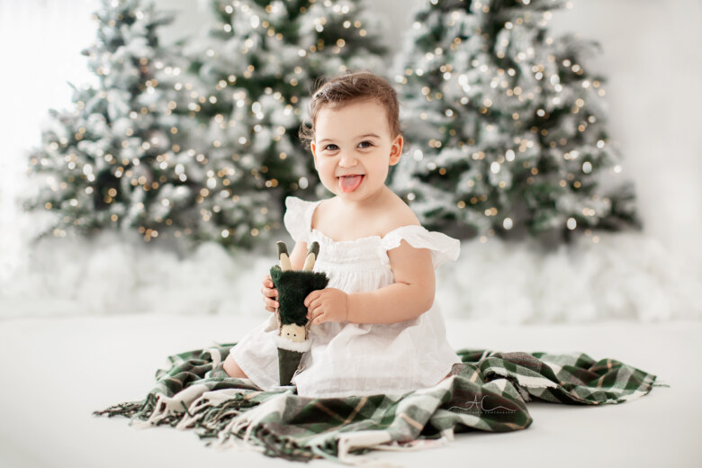 Magical Bromley Baby Christmas Photos | portrait of a Baby girl showing her tonque during a Xmas photo session