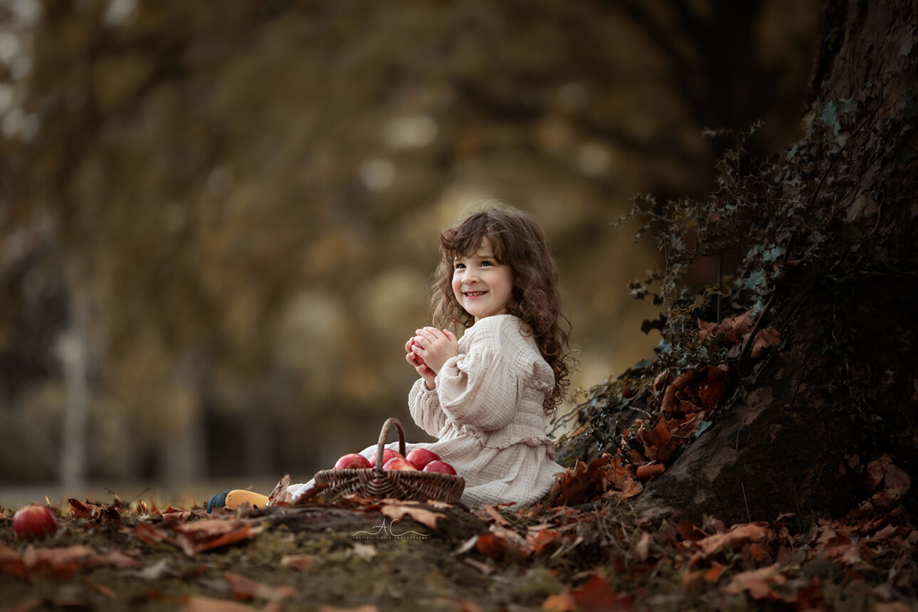 Stunning London Sibling Photo Session | Aurora & Dominic 4 5 year old girl plays with apple under the tree in a local London park