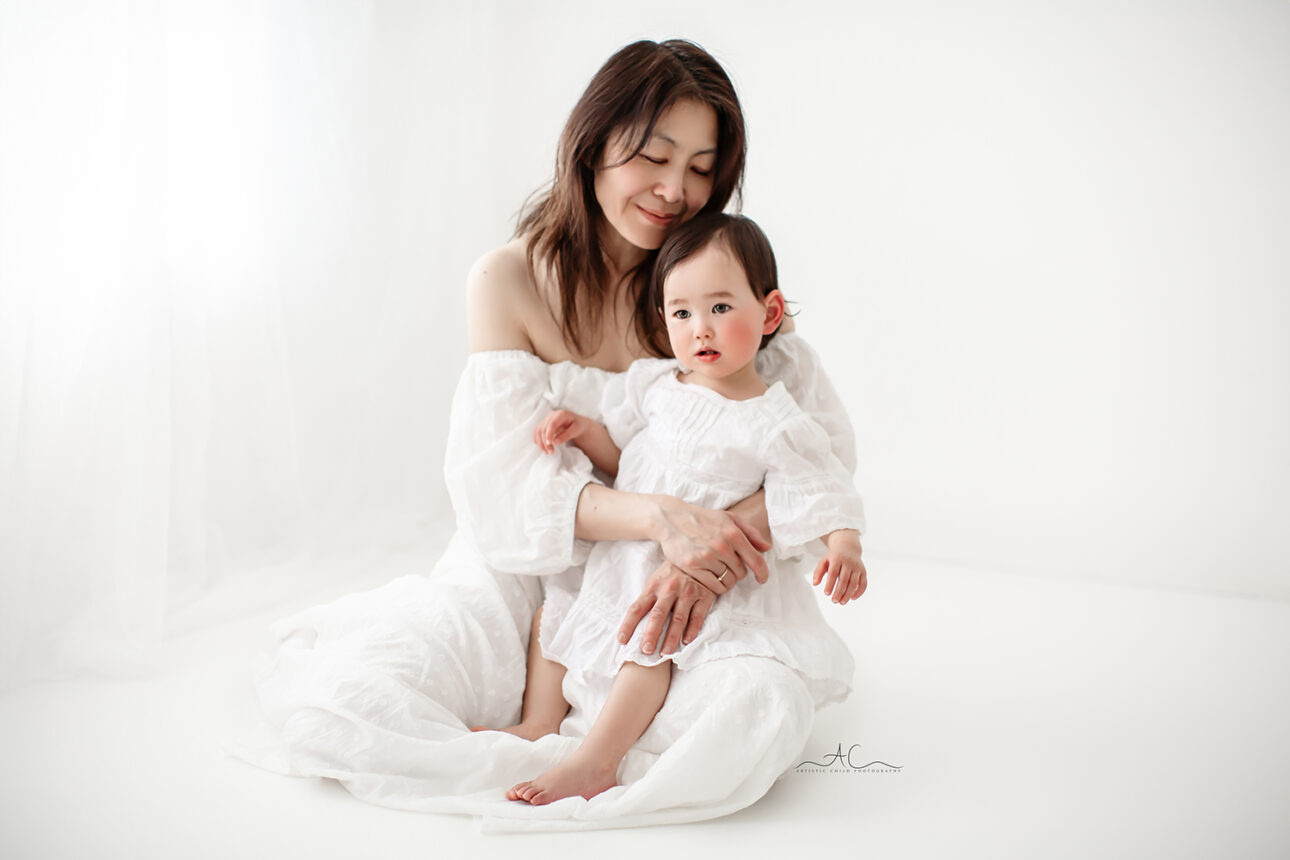 Beautiful London Mother's Day Mini Sessions | 2025 7 London Mother's Day Mini Sessions | Mum sitting on the floor and cuddling her daughter