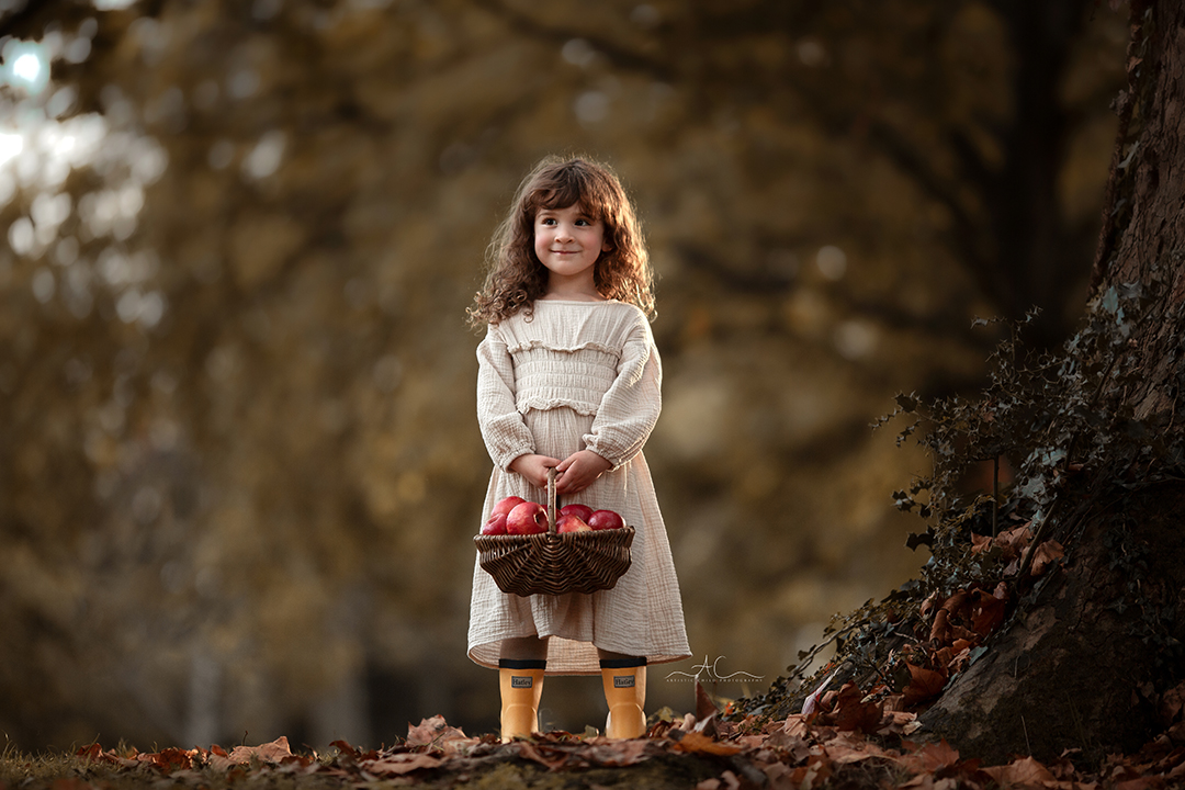 Stunning London Sibling Photo Session | Aurora & Dominic 2 Stunning London Sibling Photo Session | photo of a 5 year old girl holding a basket full of red apples in a London park