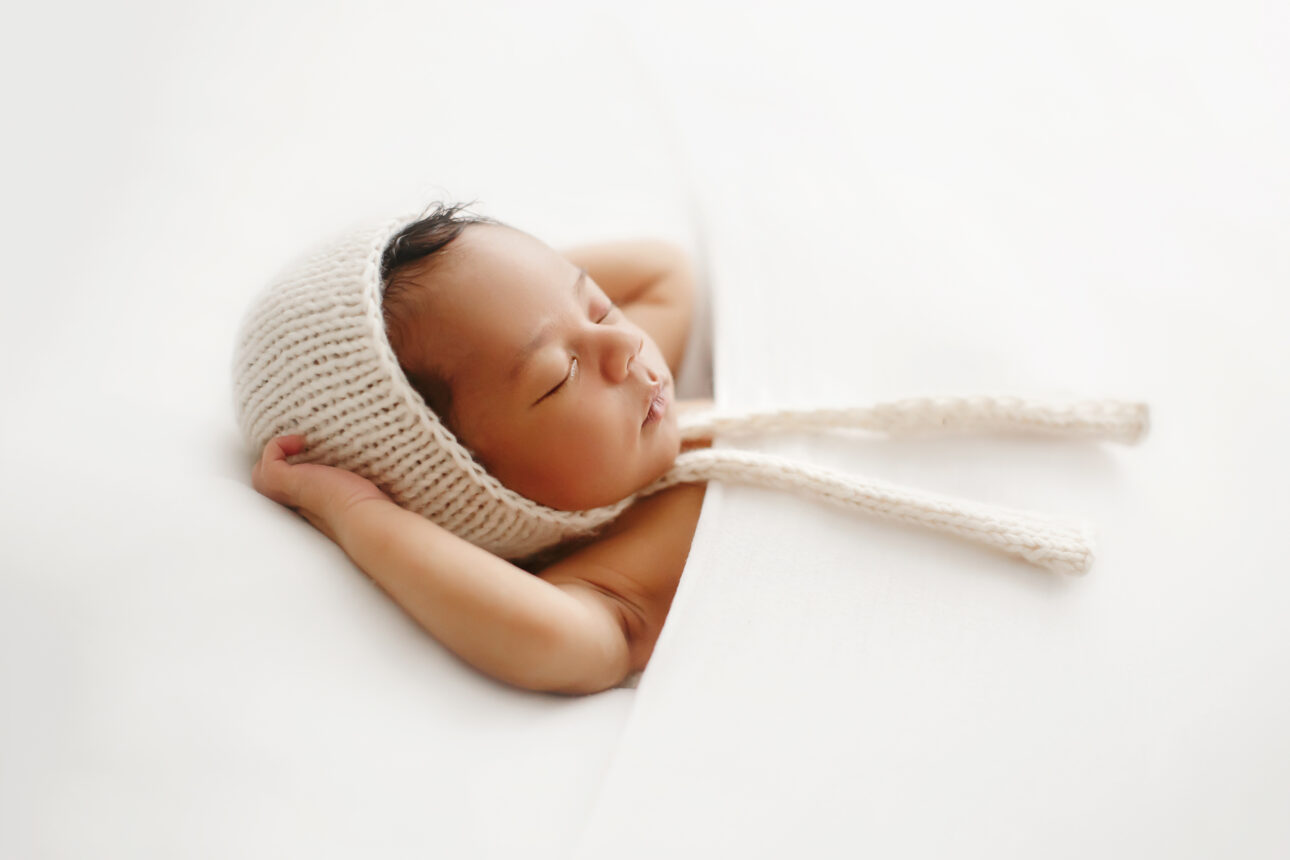 London Newborn Photography 28 London Newborn Photos | backlit portrait of a newborn baby boy in a white bonnet