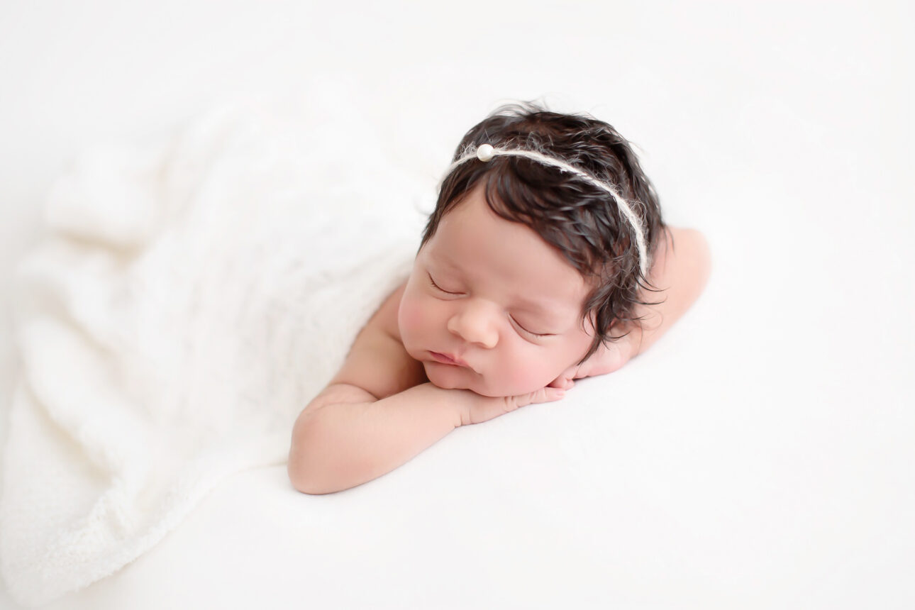 London Newborn Photography 29 London Newborn Photos | newborn baby girl sleeping on her tommy and wearing a cute tieback