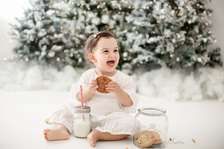 Amazing London Christmas Mini Sessions | 18 months old baby girl enjoying milk and cookies during a Xmas photoshoot