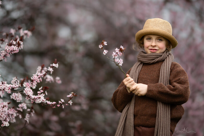 London Children and Family Blossom Photoshoot | a photo of an 8 year old boy holding a pink blossom twig