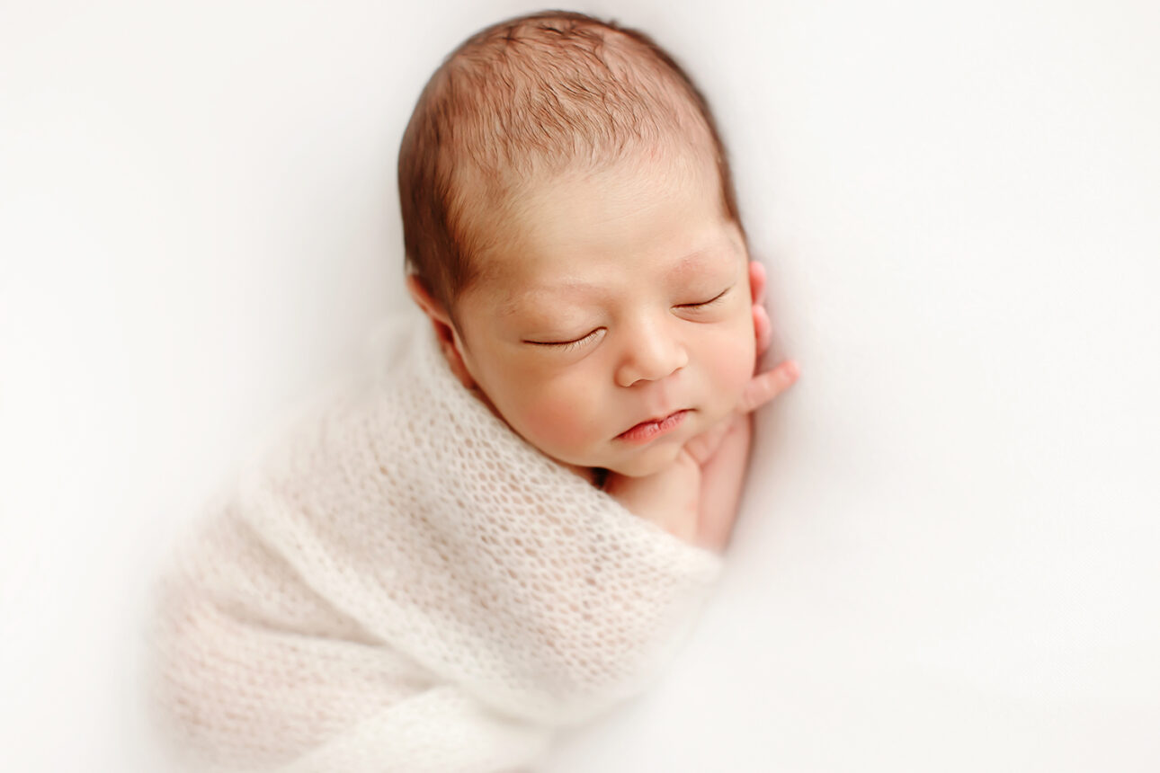 London Newborn Photos | newborn baby sleeping wrapped in a cosy knit blanket