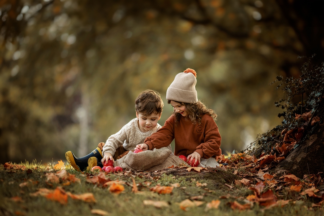 London Sibling Photography | portrait of brother and sister playing with apples during a family photoshoot in autumnal South East London park