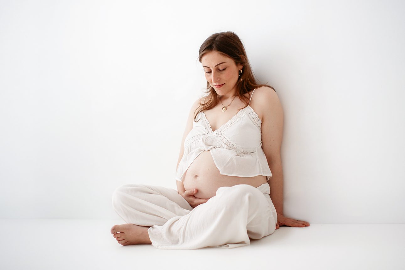 Bromley Maternity Photographer 14 Bromley Pregnancy Photographer | natural light pregnancy portrait showing mum to be cuddling her bump
